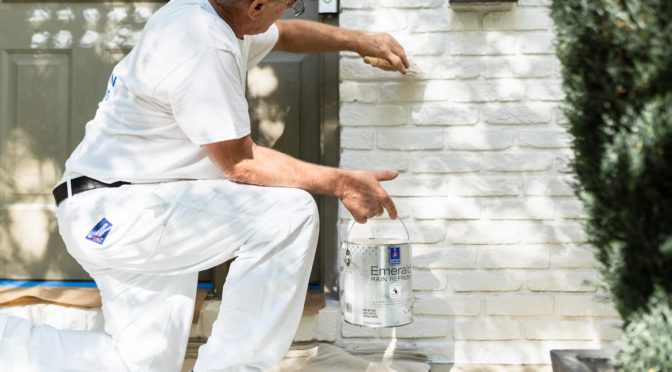 Professional painting contractor painting brick exterior